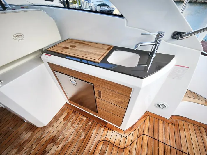  Yacht Photos Pics 2024 Sessa Marine C36 OB yacht kitchenette with sink, wooden cabinetry, and cutting board.