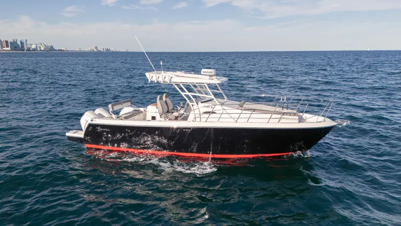  Yacht Photos Pics 2025 SeaWell 290XL boat cruising on open ocean with city skyline in background.