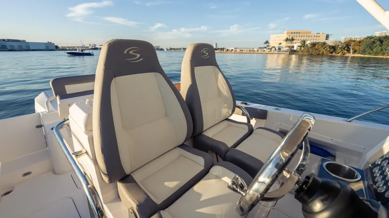  Yacht Photos Pics 2025 SeaWell 290XL boat interior with dual seats, steering wheel, and waterfront view.