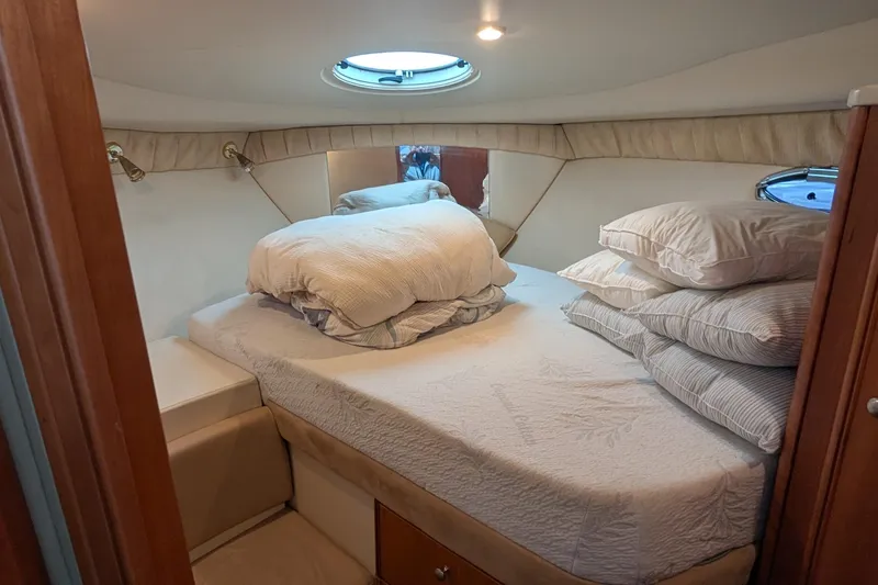 One Life Yacht Photos Pics Cozy cabin interior of 2004 Meridian 341 yacht with plush bedding and porthole window.