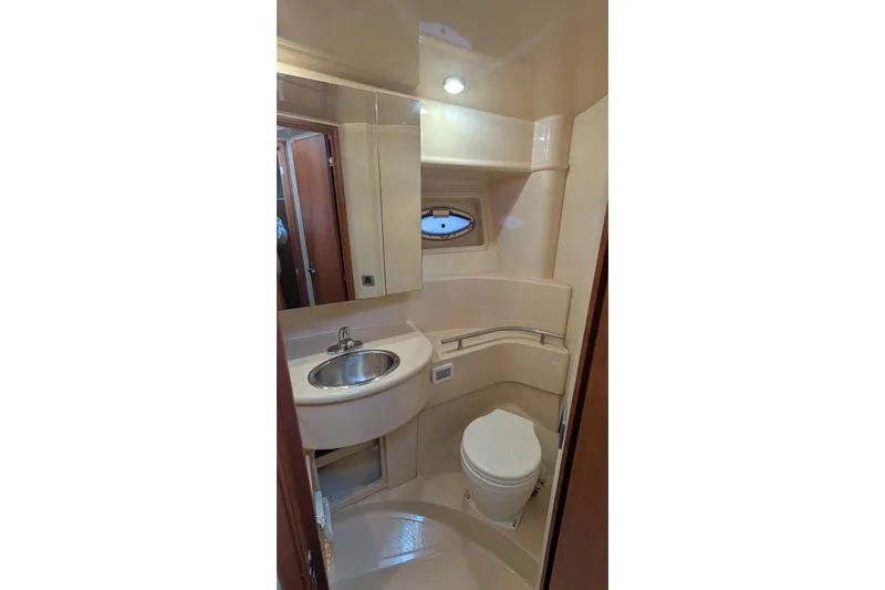 One Life Yacht Photos Pics 2004 Meridian 341 yacht bathroom with sink, toilet, and porthole window.