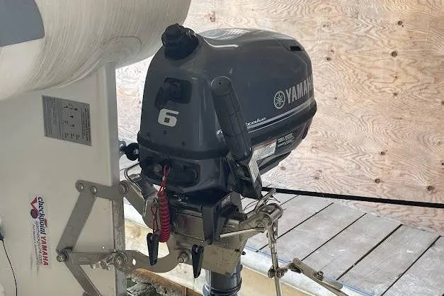 One Life Yacht Photos Pics Yamaha 6HP outboard motor on 2004 Meridian 341 boat, docked with wooden background.