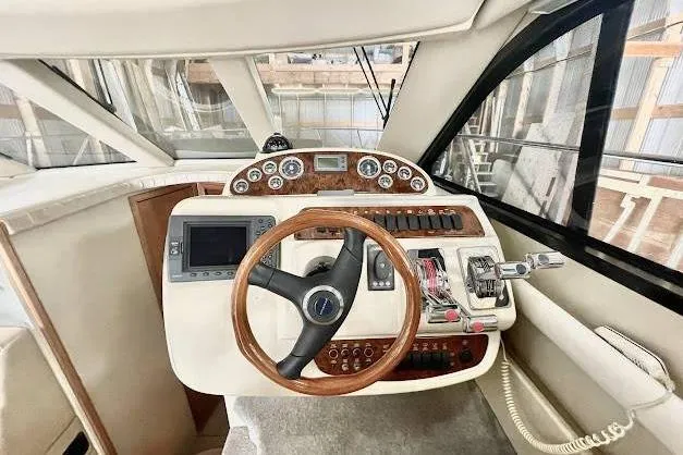 One Life Yacht Photos Pics 2004 Meridian 341 yacht helm with wooden steering wheel and navigation controls.