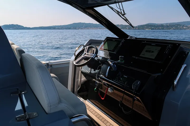  Yacht Photos Pics Interior view of 2023 Pirelli 42 yacht cockpit with steering wheel and navigation screens.