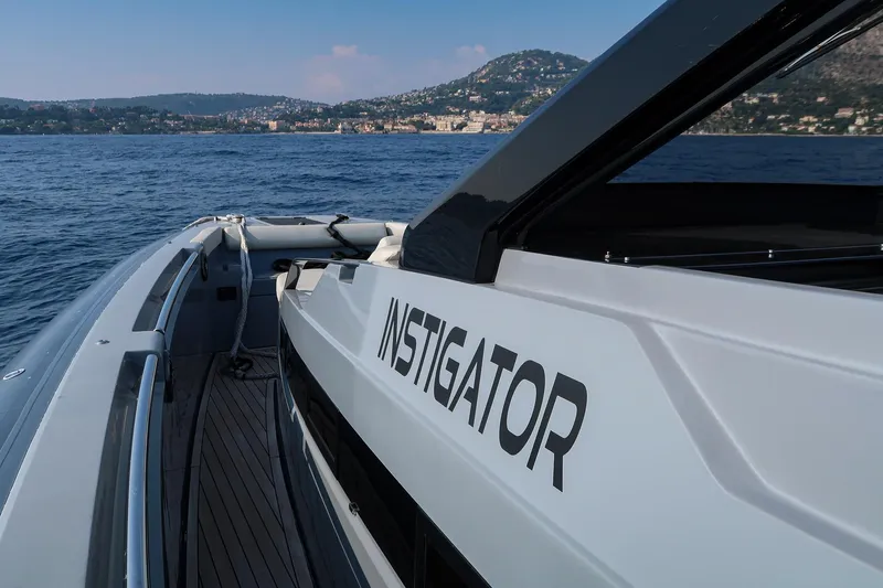  Yacht Photos Pics 2023 Pirelli 42 boat named "Instigator" cruising on a scenic coastal waterway.