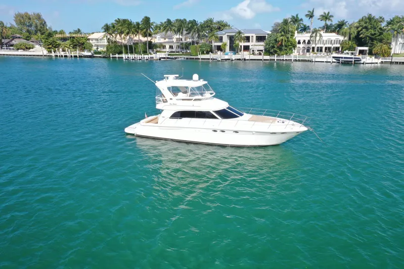  Yacht Photos Pics 2001 Sea Ray 480 Sedan Bridge yacht on clear blue water near luxury waterfront homes.