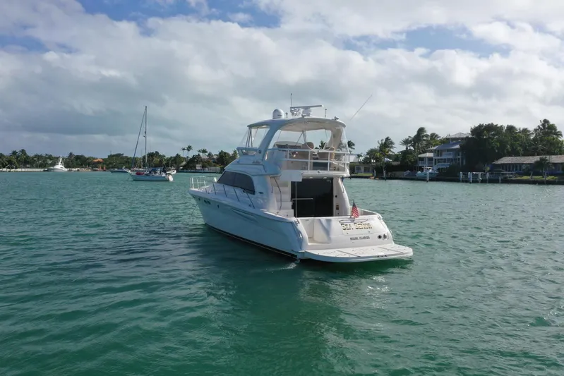  Yacht Photos Pics 2001 Sea Ray 480 Sedan Bridge yacht on calm waters, scenic background.