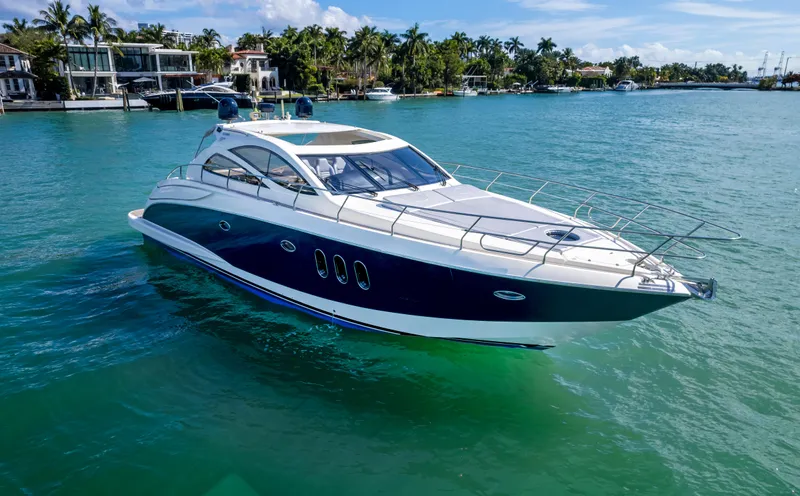 Astondoa 53 Open Yacht Photos Pics Astondoa 53 Open 2005 yacht cruising on clear blue water near luxury waterfront homes.