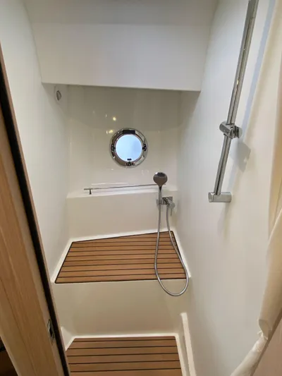  Yacht Photos Pics 2023 Beneteau Swift Trawler 41 Fly shower with wooden flooring and porthole window.
