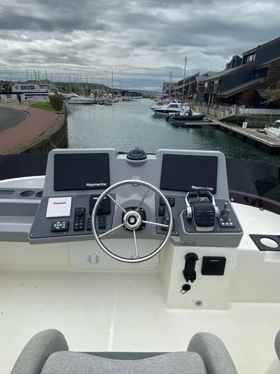  Yacht Photos Pics 2023 Beneteau Swift Trawler 41 Fly helm with dual Raymarine displays in a marina setting.