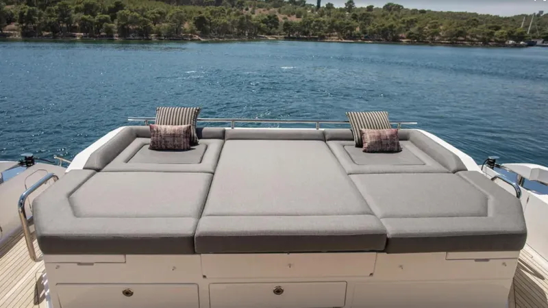  Yacht Photos Pics Luxurious sunbed on 2018 Azimut S7 yacht overlooking serene water and lush greenery.
