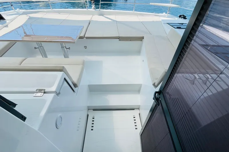  Yacht Photos Pics Luxurious 2025 Bali 4.6 yacht deck with seating and table, overlooking serene waters.