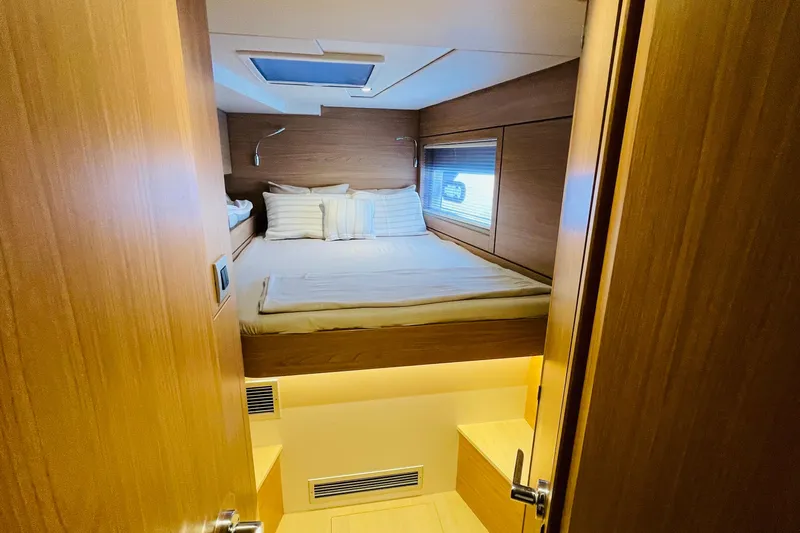  Yacht Photos Pics Cozy bedroom in 2025 Bali 4.6 yacht with wooden interior and skylight.