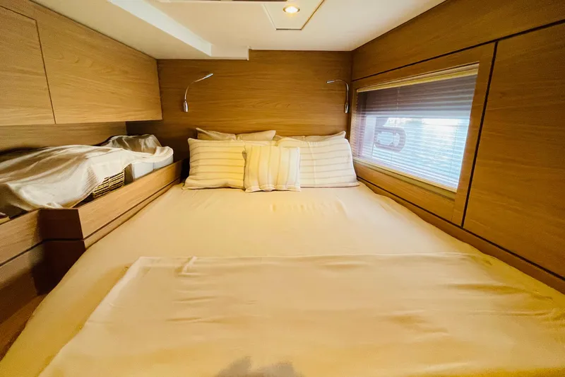  Yacht Photos Pics Cozy bedroom interior in 2025 Bali 4.6 model yacht with wooden finish and soft lighting.