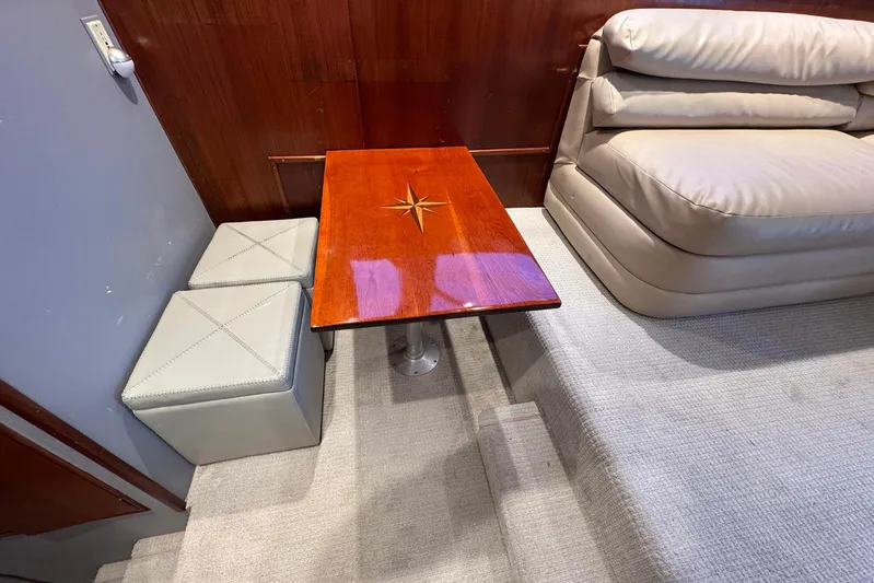 High Tide Yacht Photos Pics Interior of 1988 Buddy Davis 47 Convertible with wooden table and cushioned seating.