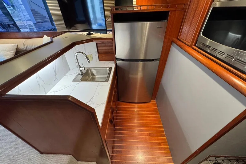 High Tide Yacht Photos Pics Compact kitchen area in a 1988 Buddy Davis 47 Convertible yacht with stainless steel appliances.