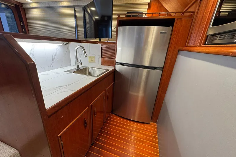 High Tide Yacht Photos Pics 1988 Buddy Davis 47 Convertible yacht kitchen with stainless steel fridge and marble countertop.