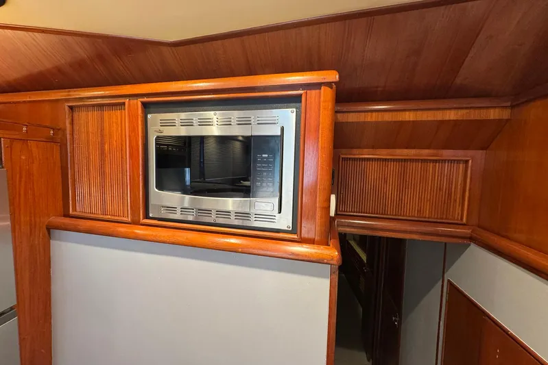 High Tide Yacht Photos Pics Wood-paneled interior of 1988 Buddy Davis 47 Convertible with built-in microwave.