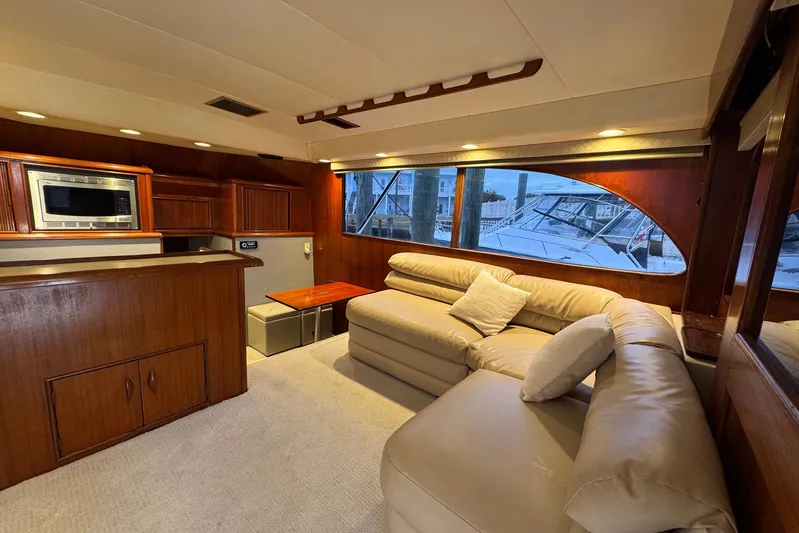 High Tide Yacht Photos Pics Luxurious interior of 1988 Buddy Davis 47 Convertible yacht with plush seating and wooden cabinetry.