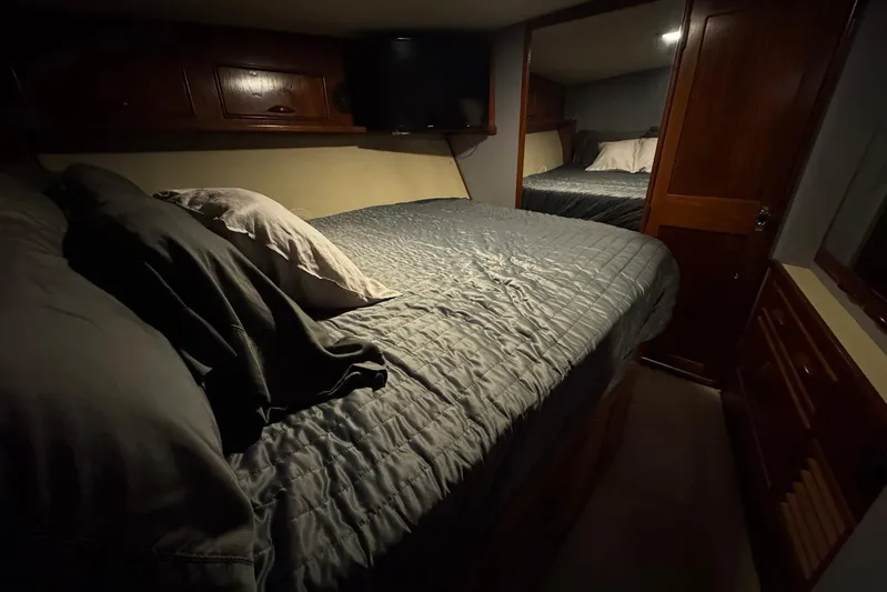High Tide Yacht Photos Pics Cozy bedroom interior of 1988 Buddy Davis 47 Convertible yacht with wooden cabinetry.