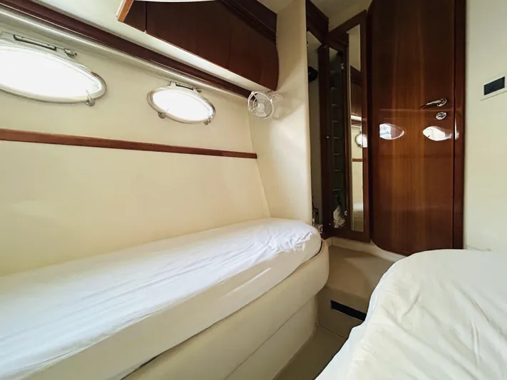  Yacht Photos Pics Interior cabin of 2006 Pershing 46 yacht with twin beds and wooden accents.