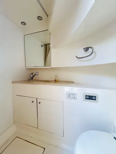  Yacht Photos Pics 2006 Pershing 46 yacht bathroom with sink, mirror, and storage cabinets.