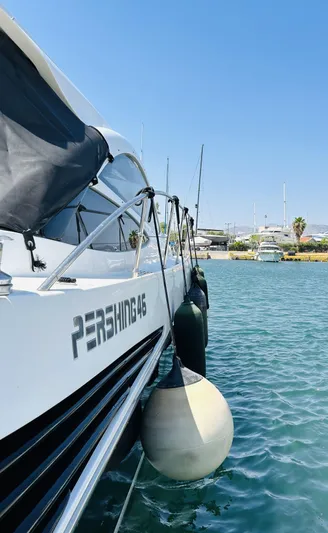 Yacht Photos Pics 2006 Pershing 46 yacht docked in a sunny marina, with clear blue water.