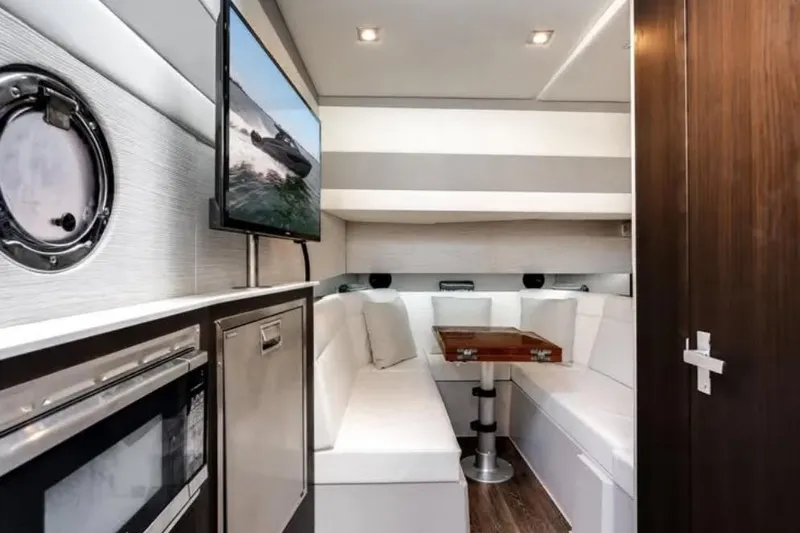  Yacht Photos Pics Luxurious interior of 2023 Cruisers 42 yacht with modern seating, TV, and kitchenette.