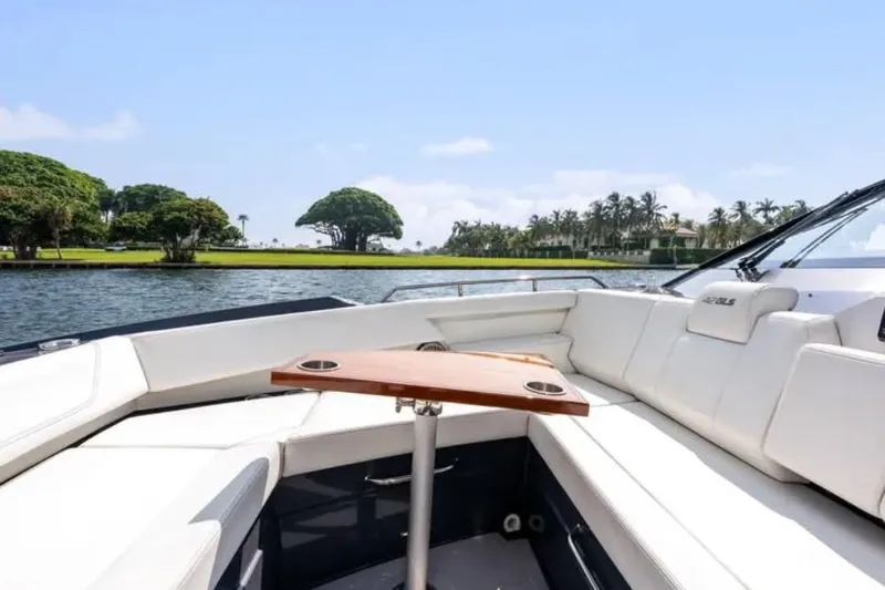  Yacht Photos Pics Luxurious 2023 Cruisers 42 yacht interior with white seating and wooden table on a sunny day.