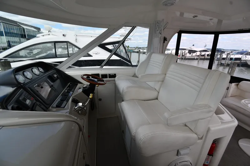Seriously Yacht Photos Pics 2005 Sea Ray 390 Motor Yacht helm with white seating and control panel, docked at marina.