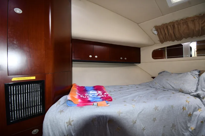 Seriously Yacht Photos Pics 2005 Sea Ray 390 Motor Yacht cabin with bed, wooden cabinets, and star-patterned bedding.