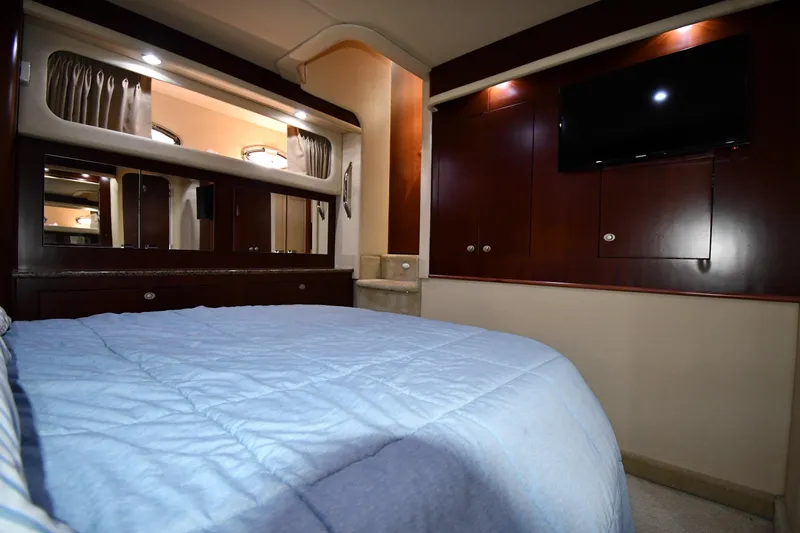 Seriously Yacht Photos Pics Luxurious 2005 Sea Ray 390 Motor Yacht bedroom with blue bedding and wood cabinetry.
