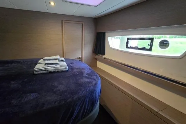 Island Nomad Yacht Photos Pics Luxurious cabin interior of 2022 Fountaine Pajot Tanna 47 yacht with plush bedding.