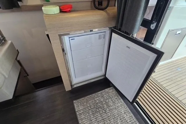 Island Nomad Yacht Photos Pics Interior view of 2022 Fountaine Pajot Tanna 47 yacht with open refrigerator.