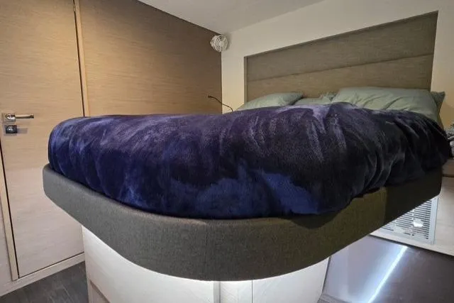Island Nomad Yacht Photos Pics Luxurious bedroom interior of 2022 Fountaine Pajot Tanna 47 catamaran with plush bedding.