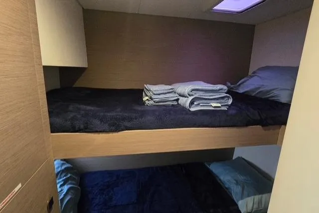 Island Nomad Yacht Photos Pics Bunk beds in 2022 Fountaine Pajot Tanna 47 yacht cabin, with folded towels and bedding.