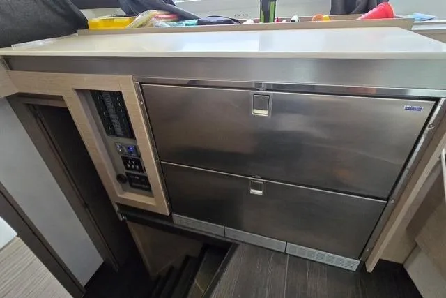 Island Nomad Yacht Photos Pics Modern kitchen area in 2022 Fountaine Pajot Tanna 47 yacht, featuring stainless steel appliances.