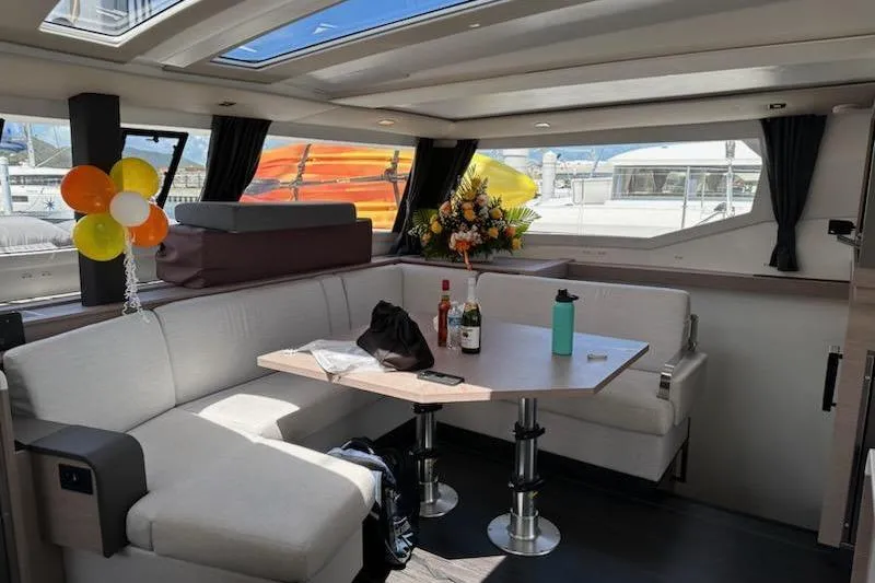 Island Nomad Yacht Photos Pics Luxurious interior of 2023 Fountaine Pajot Tanna 47 yacht with seating and decor.