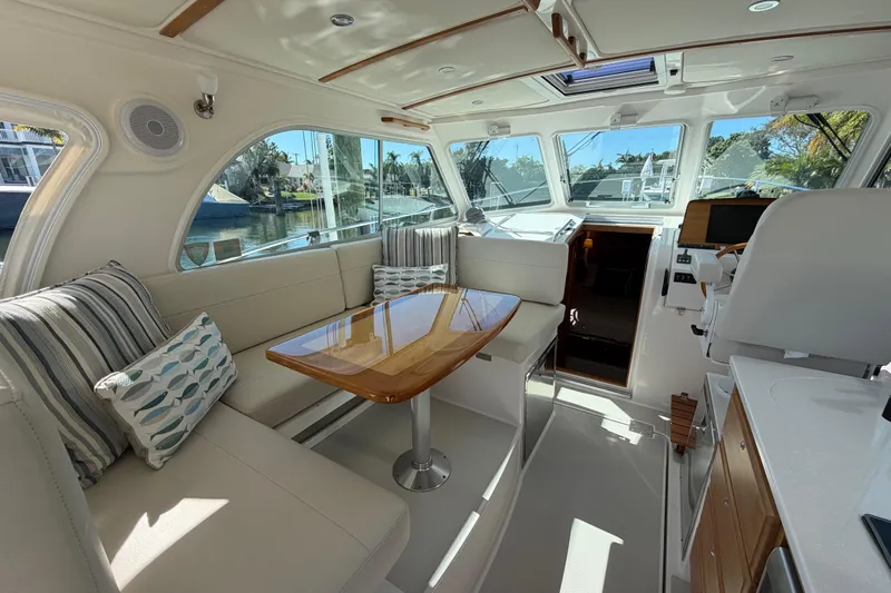 Pivot Yacht Photos Pics Luxurious interior of 2023 Back Cove 340 yacht with elegant seating and wooden table.