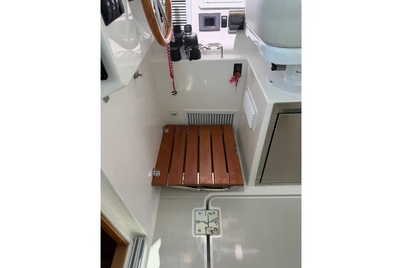 Pivot Yacht Photos Pics 2023 Back Cove 340 interior with wooden seat and control panel.