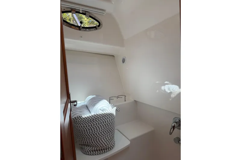 Pivot Yacht Photos Pics 2023 Back Cove 340 interior with porthole, featuring a cozy seating area and soft lighting.