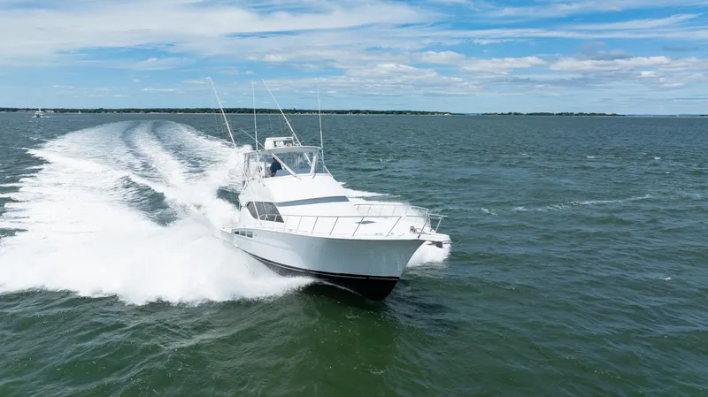 Fortitude Yacht Photos Pics Hatteras 50 Convertible 2001 cruising on open water under a clear blue sky.