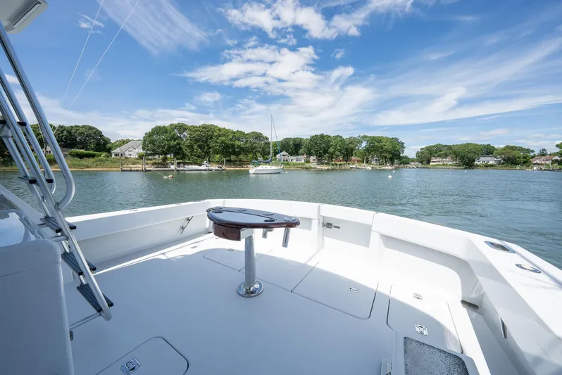 Fortitude Yacht Photos Pics 2001 Hatteras 50 Convertible yacht deck overlooking serene waterfront and lush greenery.