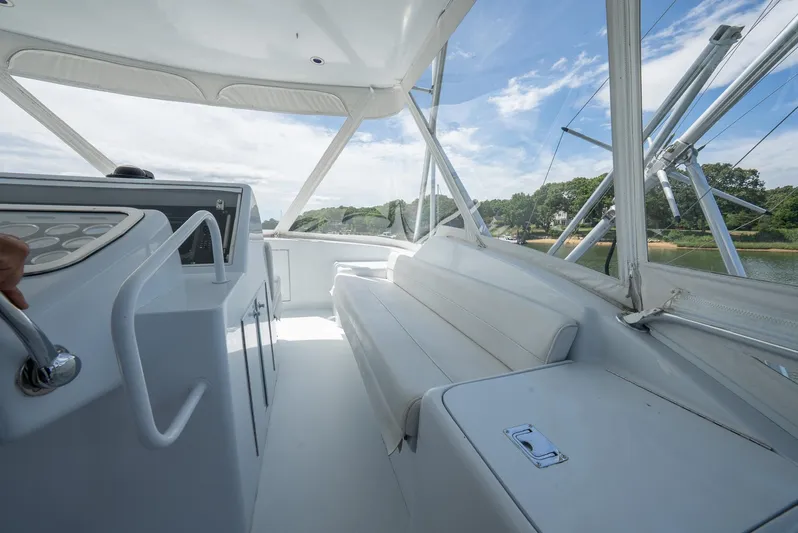Fortitude Yacht Photos Pics 2001 Hatteras 50 Convertible yacht interior with white seating and helm, under clear blue skies.