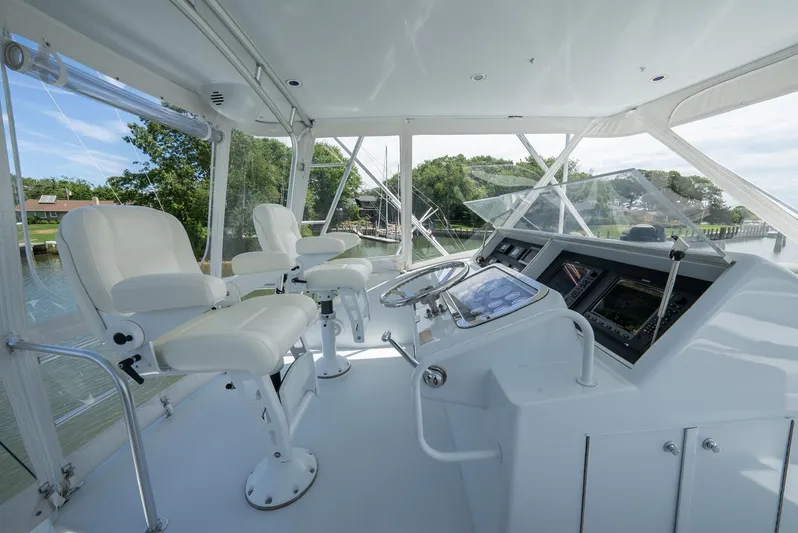Fortitude Yacht Photos Pics Helm of 2001 Hatteras 50 Convertible yacht with white seating and navigation controls.