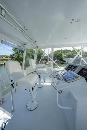 Fortitude Yacht Photos Pics Helm of 2001 Hatteras 50 Convertible yacht with white seating and modern controls.