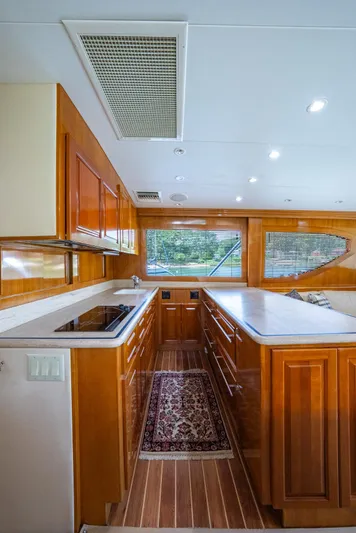 Fortitude Yacht Photos Pics Luxurious kitchen interior of 2001 Hatteras 50 Convertible yacht with wood cabinetry and modern appliances.