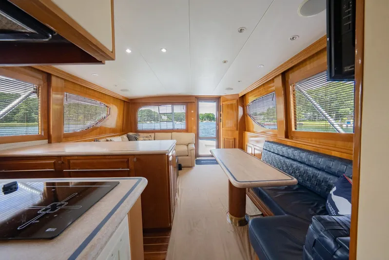 Fortitude Yacht Photos Pics Luxurious interior of 2001 Hatteras 50 Convertible yacht with wood finishes and seating area.