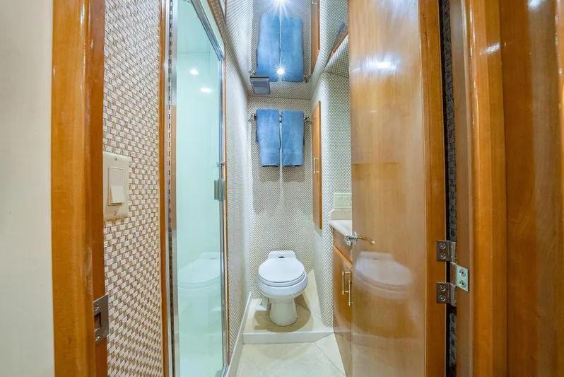 Fortitude Yacht Photos Pics Luxurious bathroom in 2001 Hatteras 50 Convertible yacht with wood accents and modern fixtures.