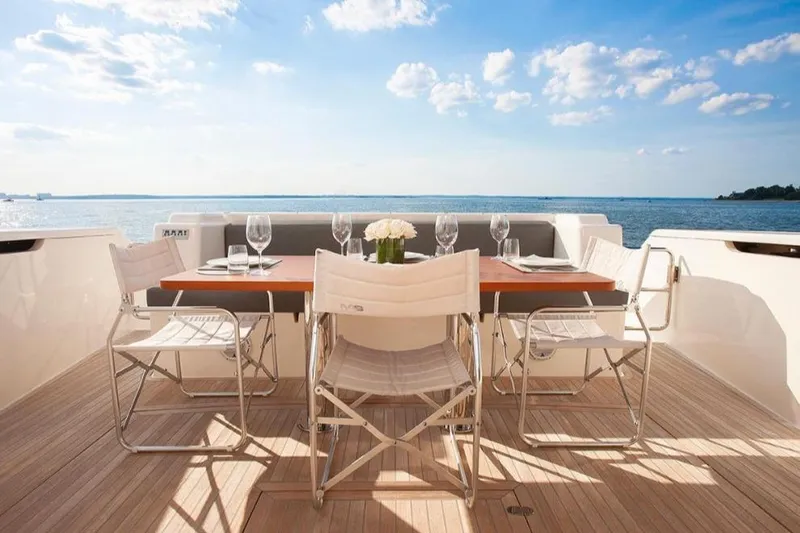 Matsu Yacht Photos Pics Outdoor dining setup on 2018 Ferretti Yachts 650, overlooking serene ocean view.